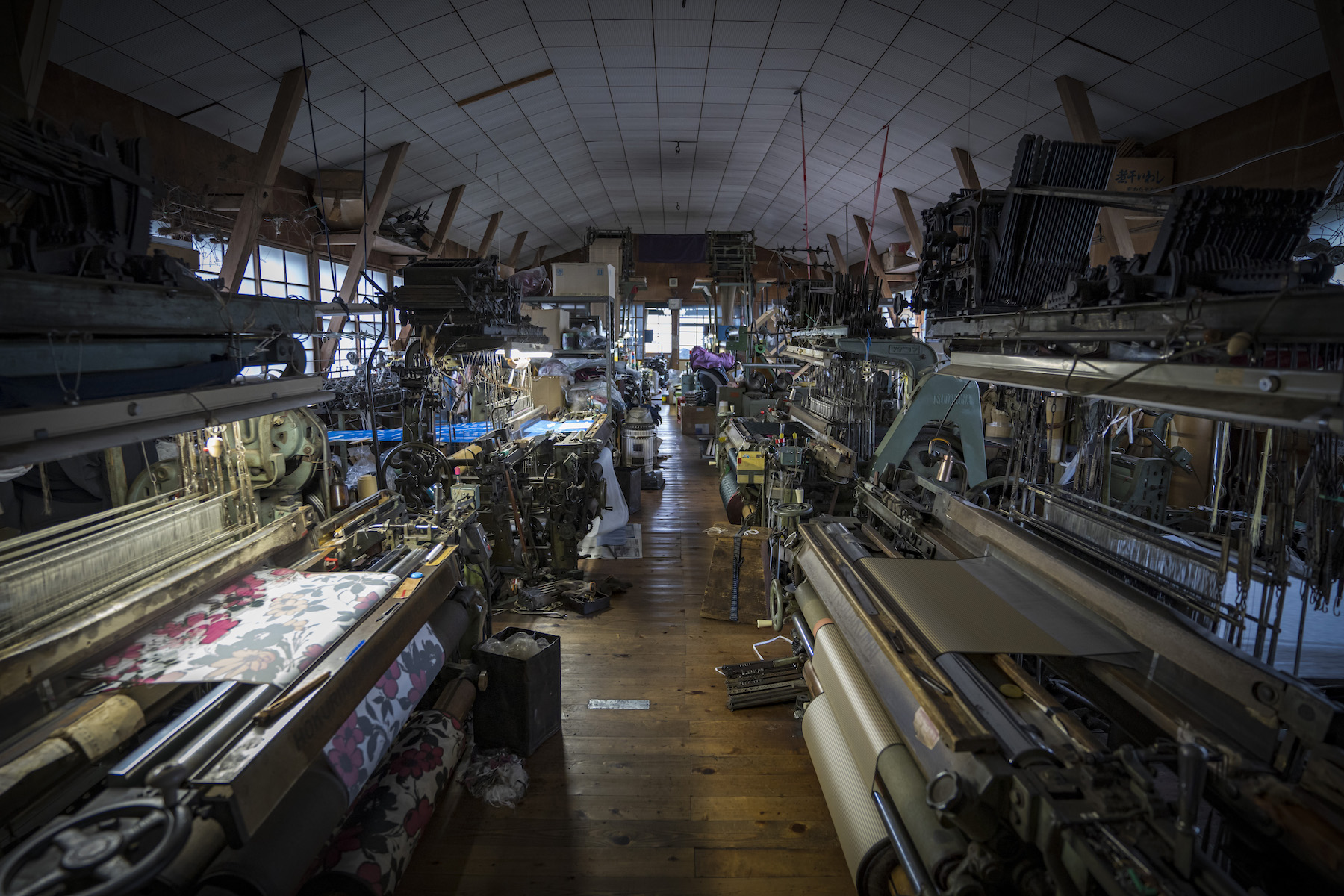 100余年の歴史ある舟久保織物の工場には、50年以上、大切に使い続けている「シャトル織機」や「レピア織機」が「ドビー」「ジャガード」を適宜組み合わせた状態で並ぶ。