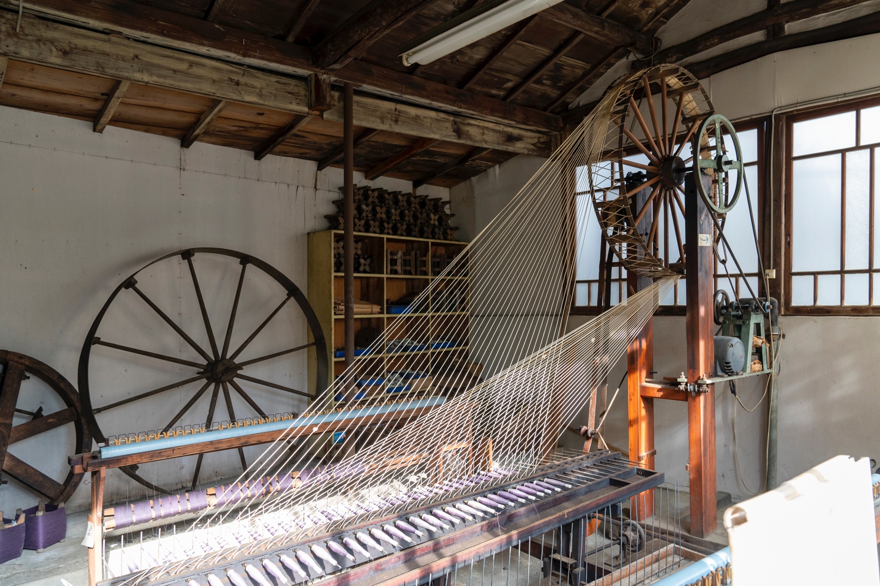 現役に戻った八丁撚糸機。八丁撚糸機は1783年、岩瀬吉兵衛により水力を動力源にした機械として考案されたという。1メートルに約3千回もの強い撚りを緯糸にかける。